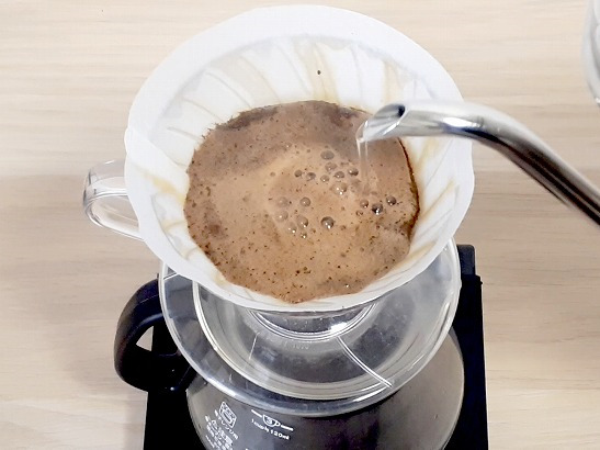 コーヒーの粉全体にお湯を注ぎ抽出している様子