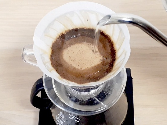 コーヒーの粉の中心部分にお湯を注いで抽出している様子